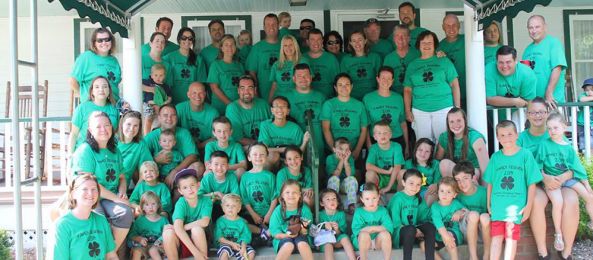 A large group of people posed on the steps of Baumann's Brookside