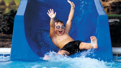 Kid sliding down a waterslide.